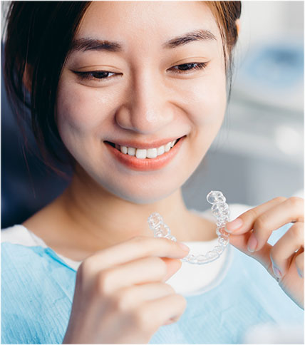 Woman holding a clear aligner.
